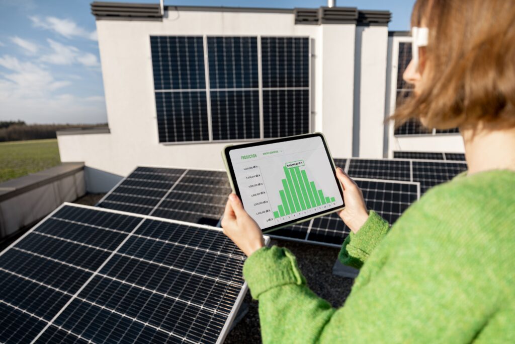 Eine Person schaut über ein Tablet wie viel ihre Solaranlage an Energie ihr eingebracht hat